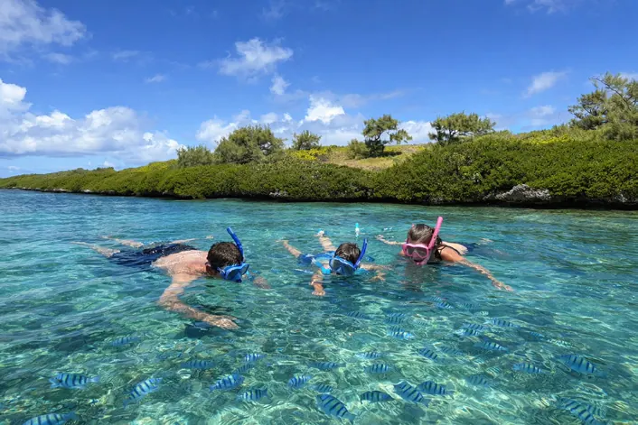 Guests snorkelling in the turquoise lagoon near Ile aux Cerfs
